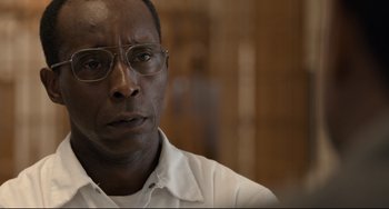 Movie still from “Just Mercy” (2019), directed by Destin Daniel Cretton – A person wearing glasses and a white shirt; Close Up shot, Low angle