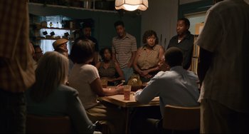 Movie still from “Just Mercy” (2019), directed by Destin Daniel Cretton – A group of people sitting around a table; Wide shot, Over the shoulder angle