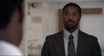 Movie still from “Just Mercy” (2019), directed by Destin Daniel Cretton – A person wearing a suit and tie; Close Up shot, Over the shoulder angle