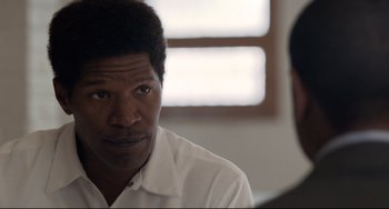 Movie still from “Just Mercy” (2019), directed by Destin Daniel Cretton – A man in a white shirt is talking to another man; Close Up shot, Over the shoulder angle