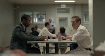 Movie still from “Just Mercy” (2019), directed by Destin Daniel Cretton – A group of people sitting at a table eating food; Wide shot, Over the shoulder angle