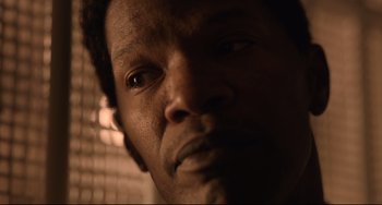 Movie still from “Just Mercy” (2019), directed by Destin Daniel Cretton – A man's face in a dark room; Extreme Close Up shot, Low angle