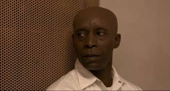 Movie still from “Just Mercy” (2019), directed by Destin Daniel Cretton – A man with a bald head is standing in front of a wall; Close Up shot, Low angle