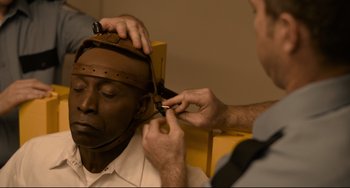 Movie still from “Just Mercy” (2019), directed by Destin Daniel Cretton – A man is cutting another man's hair with a pair of scissors; Close Up shot, High angle