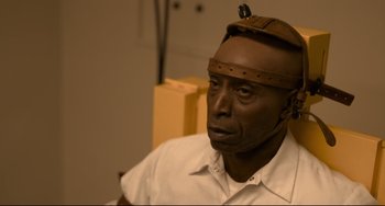 Movie still from “Just Mercy” (2019), directed by Destin Daniel Cretton – A man wearing a head piece sitting down; Close Up shot, High angle