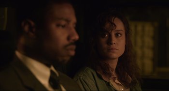 Movie still from “Just Mercy” (2019), directed by Destin Daniel Cretton – A man and a woman looking at the camera in the dark; Close Up shot, Over the shoulder angle