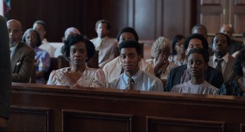 Movie still from “Just Mercy” (2019), directed by Destin Daniel Cretton – A group of people sitting in a court room; Medium shot, Over the shoulder angle