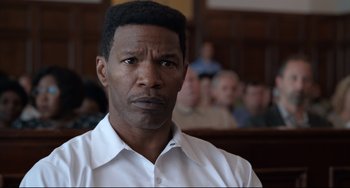 Movie still from “Just Mercy” (2019), directed by Destin Daniel Cretton – A person wearing a white shirt in a courtroom; Close Up shot, Over the shoulder angle
