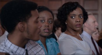 Movie still from “Just Mercy” (2019), directed by Destin Daniel Cretton – A group of people sitting next to each other in a room; Close Up shot, Over the shoulder angle