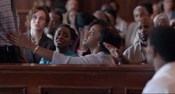 Movie still from “Just Mercy” (2019), directed by Destin Daniel Cretton – A group of people sitting in front of an audience; Medium shot, Over the shoulder angle