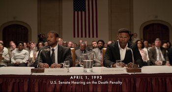 Movie still from “Just Mercy” (2019), directed by Destin Daniel Cretton – Two men sitting at a u; Medium shot, High angle