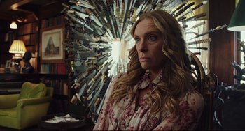 Movie still from “Knives Out” (2019), directed by Rian Johnson – A woman standing in front of a bunch of knifes; Medium shot, Over the shoulder angle