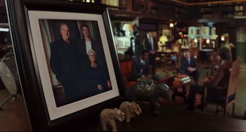 Movie still from “Knives Out” (2019), directed by Rian Johnson – A family photo is displayed in front of a picture frame; Wide shot, High angle