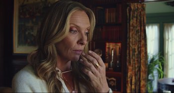 Movie still from “Knives Out” (2019), directed by Rian Johnson – A woman with long blonde hair is holding her hand up to her face; Close Up shot, Over the shoulder angle