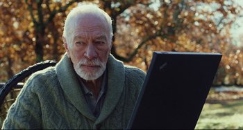 Movie still from “Knives Out” (2019), directed by Rian Johnson – An older man looking at the camera while using a computer; Close Up shot, Over the shoulder angle