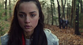 Movie still from “Knives Out” (2019), directed by Rian Johnson – A young woman in the woods looking into the camera; Close Up shot, Over the shoulder angle