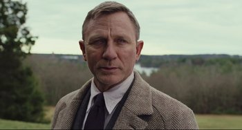 Movie still from “Knives Out” (2019), directed by Rian Johnson – A person wearing a suit and tie; Close Up shot, Over the shoulder angle