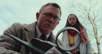 Movie still from “Knives Out” (2019), directed by Rian Johnson – A man and a woman looking through a magnifying glass; Close Up shot, Low angle