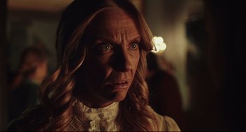 Movie still from “Knives Out” (2019), directed by Rian Johnson – A person with long blonde hair; Close Up shot, Over the shoulder angle