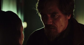 Movie still from “Knives Out” (2019), directed by Rian Johnson – A person with long hair and a goatee; Close Up shot, Over the shoulder angle