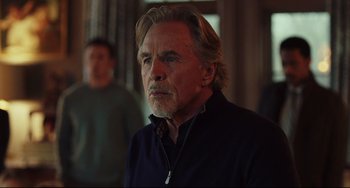 Movie still from “Knives Out” (2019), directed by Rian Johnson – An older man with long blonde hair and a goatee looking to his left; Close Up shot, Over the shoulder angle