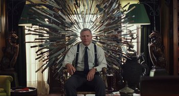 Movie still from “Knives Out” (2019), directed by Rian Johnson – A man sitting in a chair surrounded by many knifes; Medium shot, High angle