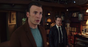 Movie still from “Knives Out” (2019), directed by Rian Johnson – A man in a suit and tie standing next to another man in a suit and tie; Medium shot, Low angle