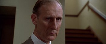 Movie still from “L.A. Confidential” (1997), directed by Curtis Hanson – An older man in a suit looking at the camera; Close Up shot, Low angle