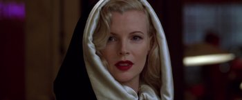Movie still from “L.A. Confidential” (1997), directed by Curtis Hanson – A woman with blonde hair and red lipstick wearing a black and white scarf; Close Up shot, Low angle
