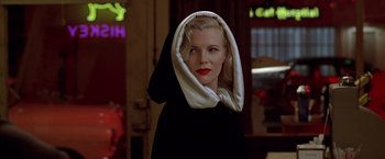 Movie still from “L.A. Confidential” (1997), directed by Curtis Hanson – A beautiful blonde woman wearing a black top and a white scarf; Close Up shot, Low angle