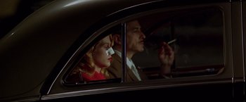 Movie still from “L.A. Confidential” (1997), directed by Curtis Hanson – A man and a woman in the back seat of a car; Close Up shot, Low angle