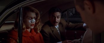 Movie still from “L.A. Confidential” (1997), directed by Curtis Hanson – A man and a woman sitting in the back of a car; Close Up shot, Low angle