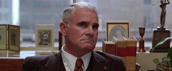 Movie still from “L.A. Confidential” (1997), directed by Curtis Hanson – An older man wearing a suit and tie; Close Up shot, Low angle