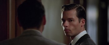 Movie still from “L.A. Confidential” (1997), directed by Curtis Hanson – A man looking into a mirror while standing next to another man; Close Up shot, Over the shoulder angle