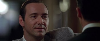 Movie still from “L.A. Confidential” (1997), directed by Curtis Hanson – A person sitting on a couch; Close Up shot, Over the shoulder angle