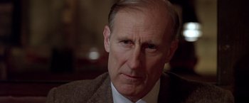 Movie still from “L.A. Confidential” (1997), directed by Curtis Hanson – An older man wearing a suit and tie; Close Up shot, Low angle