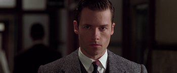 Movie still from “L.A. Confidential” (1997), directed by Curtis Hanson – A person wearing a suit and tie; Close Up shot, Low angle