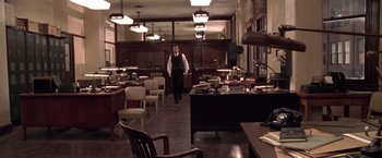 Movie still from “L.A. Confidential” (1997), directed by Curtis Hanson – A man standing in an old fashioned kitchen; Wide shot, High angle