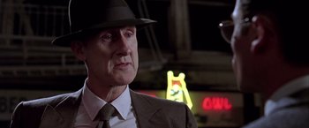 Movie still from “L.A. Confidential” (1997), directed by Curtis Hanson – An older man wearing a suit and a hat; Close Up shot, Low angle