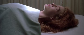 Movie still from “L.A. Confidential” (1997), directed by Curtis Hanson – A woman laying on a bed with her eyes closed; Close Up shot, Low angle