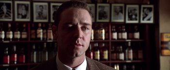 Movie still from “L.A. Confidential” (1997), directed by Curtis Hanson – A person wearing a suit and tie; Close Up shot, Low angle