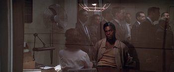 Movie still from “L.A. Confidential” (1997), directed by Curtis Hanson – A man sitting in front of a mirror in a room; Medium shot, Over the shoulder angle