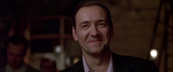 Movie still from “L.A. Confidential” (1997), directed by Curtis Hanson – A person wearing a suit and tie; Close Up shot, Low angle