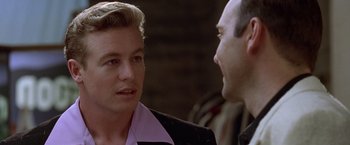 Movie still from “L.A. Confidential” (1997), directed by Curtis Hanson – A man talking to another man in front of a brick wall; Close Up shot, Over the shoulder angle