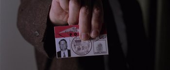Movie still from “L.A. Confidential” (1997), directed by Curtis Hanson – A person holding a piece of paper in their hand; Extreme Close Up shot, Overhead angle