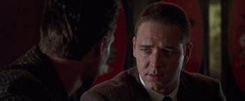 Movie still from “L.A. Confidential” (1997), directed by Curtis Hanson – A man in a suit and tie talking to another man in a suit and tie; Close Up shot, Over the shoulder angle