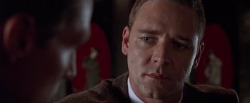 Movie still from “L.A. Confidential” (1997), directed by Curtis Hanson – A man that is staring at the camera; Close Up shot, Over the shoulder angle