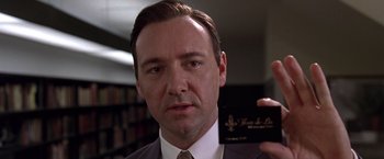Movie still from “L.A. Confidential” (1997), directed by Curtis Hanson – Kevin spacey in a suit and tie in a library; Close Up shot, Low angle