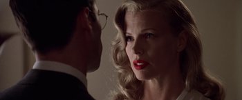 Movie still from “L.A. Confidential” (1997), directed by Curtis Hanson – A man and a woman face to face in a dark room; Close Up shot, Over the shoulder angle