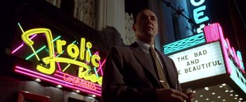 Movie still from “L.A. Confidential” (1997), directed by Curtis Hanson – A man standing in front of a neon sign; Medium shot, Low angle
